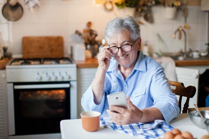 Woman smiling on phone in kitchen