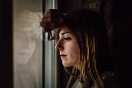 Woman looking out window thoughtfully